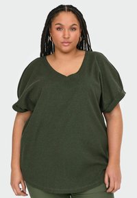 Mørkegrøn, ribbet T-shirt med korte ærmer, V-udskæring og pufærmer. Toppen har en løs pasform og en subtil tekstur.