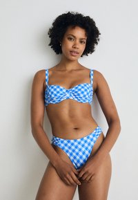 Kék kockás mintájú bikini, struktúrált, cropped fazonú toppal és magas derekú alsóval. Állítható pántokkal és redőzött részlettel a fronthoz.
