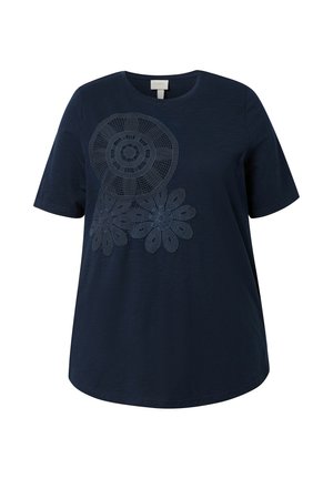Tmavě modré tričko s krátkým rukávem, kulatým výstřihem a tmavou krajkovou aplikací květinových vzorů na horní levé přední straně.