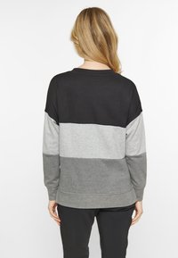 Maglione con collo a giro, caratterizzato da blocchi di colore orizzontali in nero, grigio chiaro e grigio scuro. Realizzato in tessuto morbido con maniche lunghe.