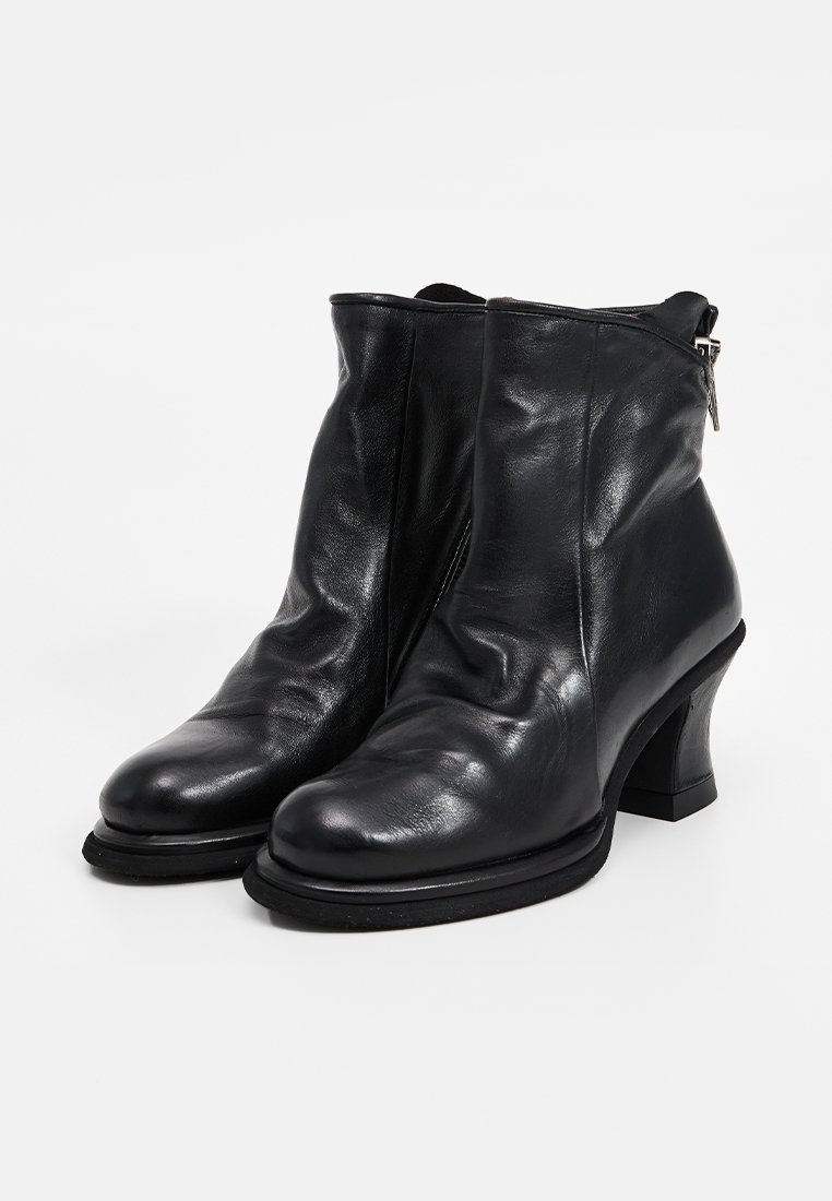 Czarne skórzane botki za kostkę z zaokrąglonym czubkiem, średniej wysokości blokowym obcasem i detalem w postaci zamka błyskawicznego z boku. Gładka tekstura z delikatnym marszczeniem.