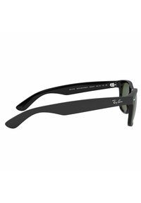 Occhiali da sole Ray-Ban Wayfarer con montatura in plastica nera opaca, lenti verdi e dettagli in metallo argentato sulle tempie. Numero di modello RB 2132.
