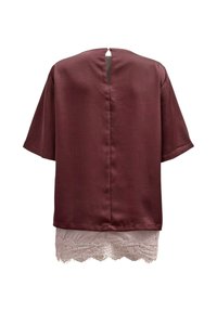 Blouse bordeaux foncé à manches courtes avec une ouverture en forme de clé dans le dos et bordure en dentelle rose clair à l'ourlet.