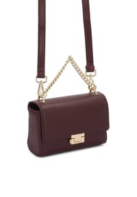 Torba iz Burgundskega usnja s strukturirano obliko, zlato strojno opremo in odstranljivim verižnim trakom. Ima magnetno zapiranje na okvir.