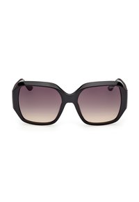Lunettes de soleil carrées surdimensionnées noires avec verres marron dégradés et branches épaisses, vue de face sur fond blanc.
