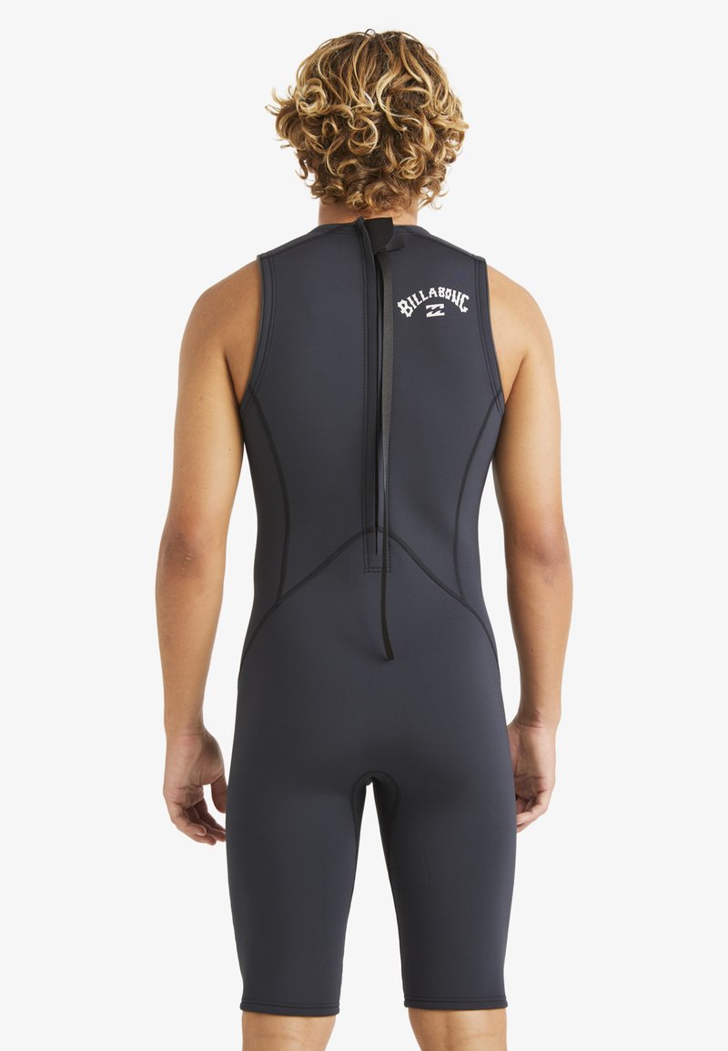 Traje de neopreno negro con diseño sin mangas y pierna hasta la rodilla. Presenta un zipper en la parte posterior y un logo blanco en la parte superior de la espalda. Textura suave.