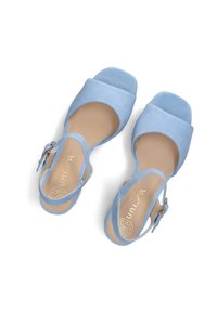 Light blue suede sandals with a square toe design, ankle strap, and a buckle detail. Flat sole and soft texture.