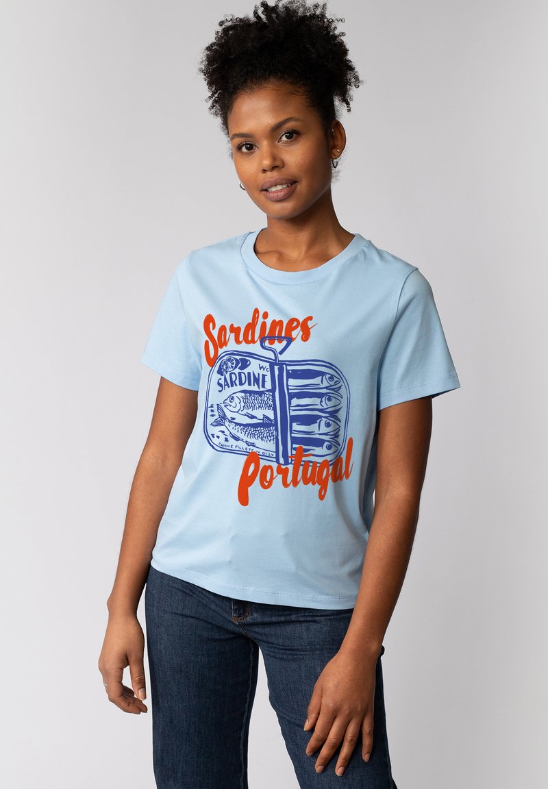 T-shirt en coton bleu clair avec un imprimé graphique d'une boîte de sardines, accompagné d'un texte bleu et orange indiquant "Sardines Portugal". Manches courtes.