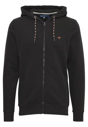 Crna zip-up dukserica napravljena od mekog materijala. Ima kapuljaču svezanu uzicom, oznaku na grudima i prednje džepove. Rukavi su prilagođeni.