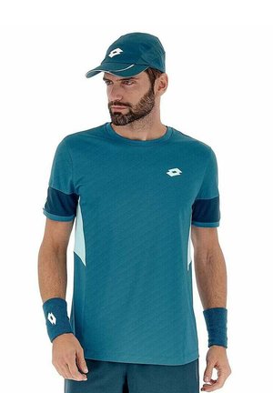 Tee in Türkis mit diagonalen Designs und hellen Akzenten, kombiniert mit passender Mütze und Handgelenkbändern für einen harmonischen Look.