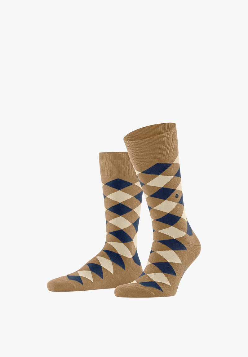 Chaussettes couleur sable avec un motif à losanges en crème et bleu marine, fabriquées en tissu texturé avec un bord-côte pour un ajustement sûr.