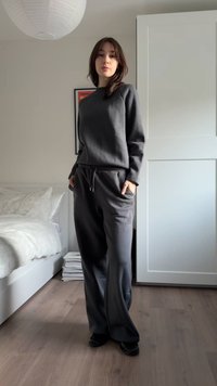 Yhdenmukainen tummanharmaa vetoketjullinen collegepaita ja leveälahkeiset collegehousut, jotka on valmistettu pehmeästä kankaasta ja joissa on kiristysnyöri vyötäröllä sekä sivutaskut.