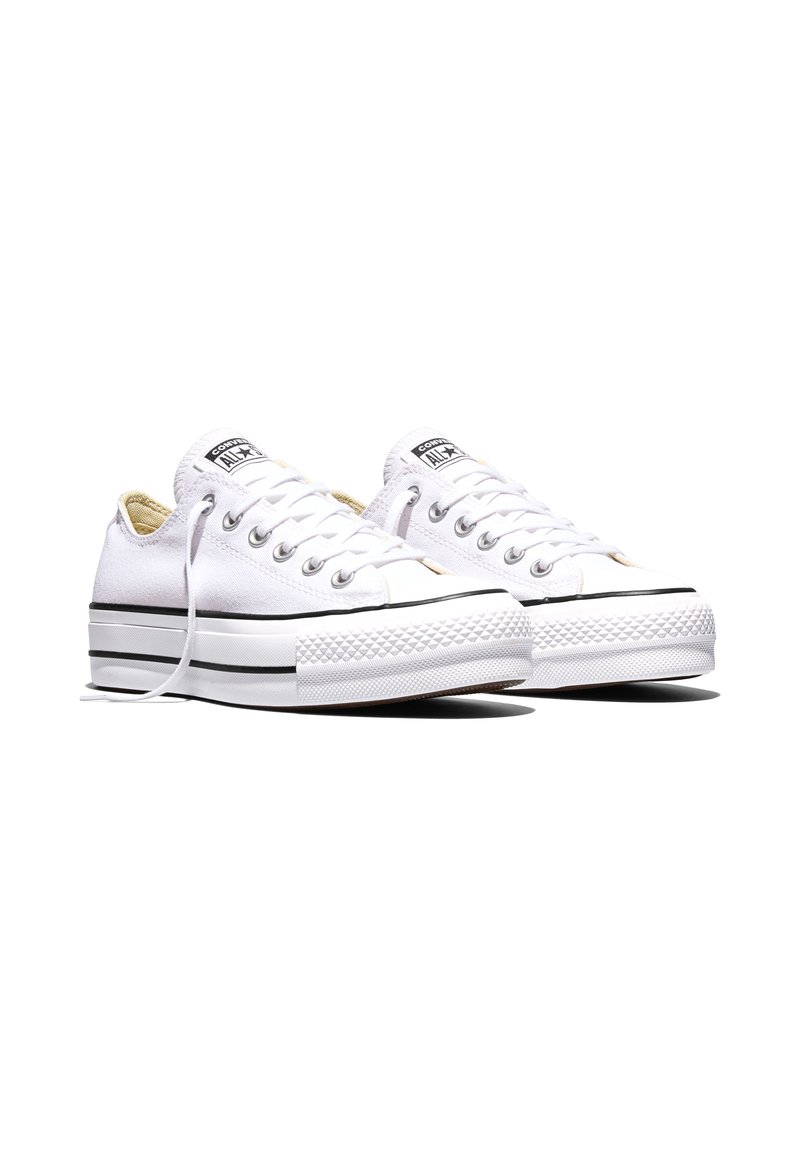 Coppia di sneakers Converse All Star bianche basse con suola platform e dettagli a righe nere, lacci parzialmente sbottonati.