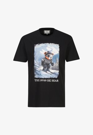 Schwarzes T-Shirt mit einer Grafik eines Bären, der im Schnee Ski fährt, eine Skibrille und einen Hut trägt, mit Berglandschaft und Text "THE 19V69 SKI BEAR."