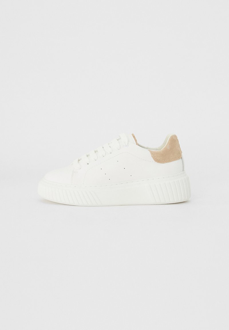 Baltas sneakers ar gludu ādas augšdaļu, ar perforētiem elementiem un brūnu zamša akcentu uz papēža. Aprīkoti ar biezu, teksturētu gumijas zoli.