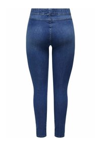 Jeans skinny azul oscuro con una textura de denim suave, cintura alta y detalles de costura mínimos, diseñados para ajustarse estrechamente a lo largo de las piernas.