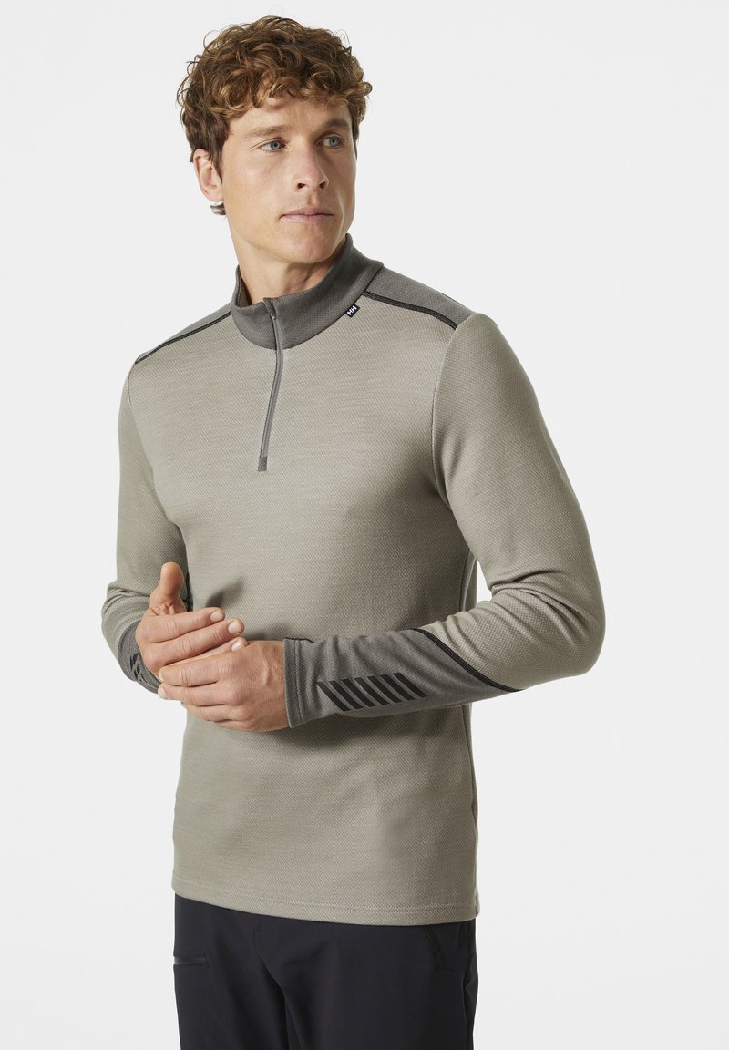 Camisa de manga larga gris claro con un cuello de media cremallera, puños en gris oscuro que contrastan y presentan un sutil patrón a rayas. Diseño de tela texturizada.