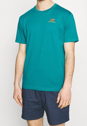 Tealová bavlněná tričko s krátkým rukávem a kulatým výstřihem. Na hrudi se nachází malé vícobarvené logo "New Balance".
