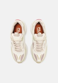 Lys beige sporty sko laget av mesh og lærmaterialer, med kremfargede detaljer, en polstret såle og diskrete gullakenter.