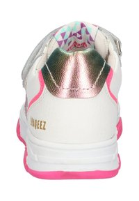 Chaussure de sport blanche avec un accent de talon métallique brillant, semelle rose et doublure intérieure à motifs. Comprend un détail de marque.