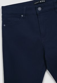 Granatowe bawełniane spodnie o prostym kroju, z przednią kieszenią, zapięciem na guziki i delikatnymi detalami przeszycia.