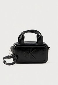Czarna lakierowana torebka na dwa górne uchwyty, z wytłoczonym logo "cK" na przodzie oraz odpinanym paskiem. Kompaktowy, prostokątny kształt o gładkiej fakturze.