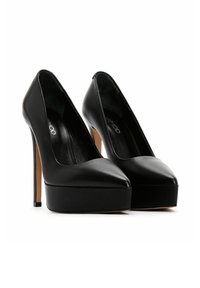 Zapatos de tacón alto negros con punta afilada, material de cuero, base de plataforma y tacones de aguja. Textura suave y acentos de diseño mínimos.