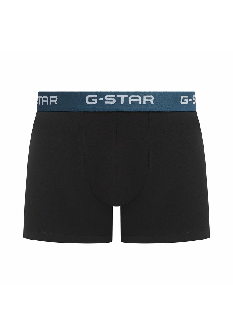 Sous-vêtements noirs en boîte avec un design de couleur unie, comportant une ceinture élastique bleue avec le logo "G-STAR" en blanc. Texture lisse, forme ajustée.