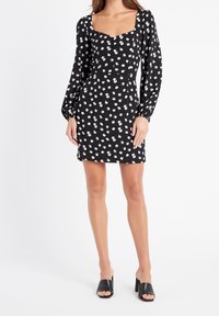 Černé květinové šaty se čtvercovým výstřihem, dlouhými nafouknutými rukávy a délkou nad kolena. Mají malé vzory bílých a růžových květin.