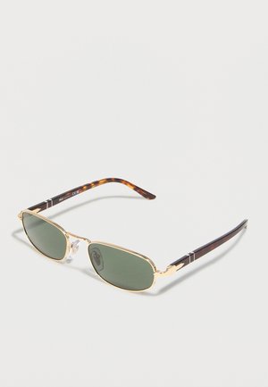 Obdĺžnikové slnečné okuliare so zelenými šošovkami a zlatým kovovým rámom s ramenami v korytnačinej farbe, zobrazené na jednoduchom bielom pozadí.