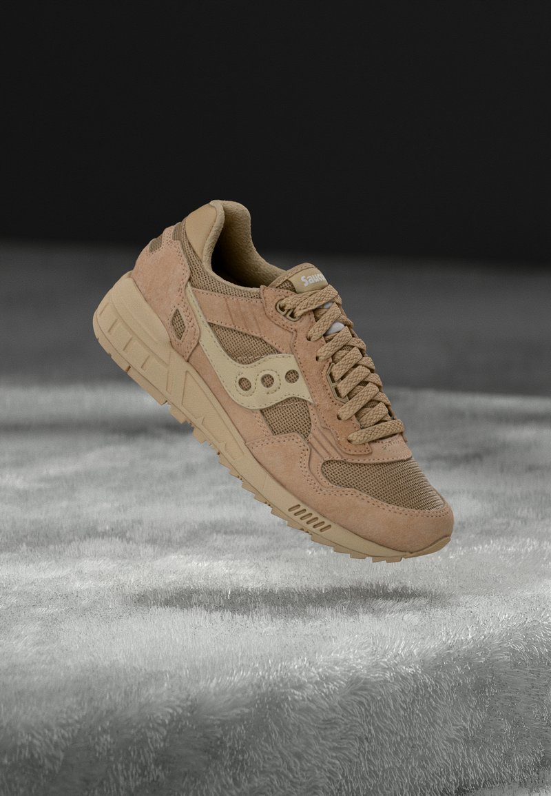 Tenisica od brušene kože u boji konjaka i mrežastog materijala s teksturiranom površinom, istaknutim vezicama i prepoznatljivim logotipom. Ima podstavljen okovratnik i izdržljiv gumeni potplat.