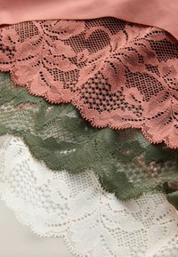 Csipke három rétegben: barackszínű, olívazöld és fehér. Minden réteg gazdag virágmintákkal és hullámos széllel rendelkezik, könnyű textúrájú.