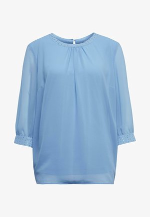 Lichtblauwe bloes met driekwartmouwen, geplooide voorkant en decoratieve studs rond de kraag en manchetten. Transparante stof.