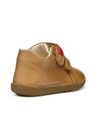 Sneaker in pelle marrone con una fascia in velcro e un accentuazione rossa. Presenta una finitura testurizzata e una suola in gomma flessibile, che garantiscono comfort e aderenza.
