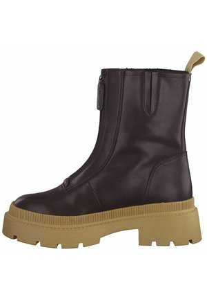 Bottine en cuir marron avec fermeture éclair sur le côté, semelle en caoutchouc texturée et design minimaliste. Dispose d'une petite languette au talon.