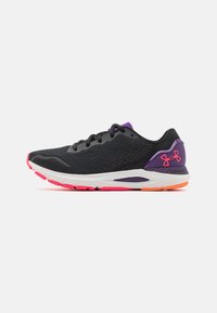 Scarpe da ginnastica nere con tomaia in rete, dettagli viola e una suola intermedia bianca. Presentano una suola esterna rosa distintiva e un dettaglio di branding sul tallone.