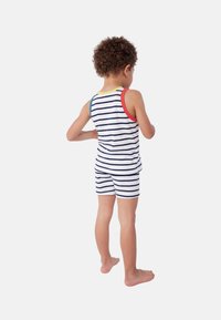 Completo canotta a righe e pantaloni corti in bianco, blu navy e accenti multicolori. Tessuto morbido, design senza maniche e pantaloni corti lunghi fino al ginocchio.