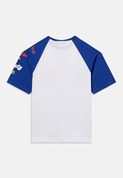 Λευκό t-shirt με μπλε μανίκια raglan, με πολύχρωμο γραφικό κείμενο στο αριστερό μανίκι.