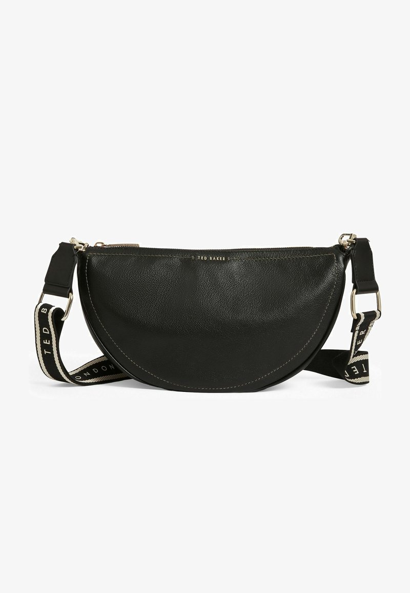 Sac bandoulière en cuir noir de forme demi-lune, avec une fermeture éclair, une sangle contrastante avec logo, et des détails de couture discrets.