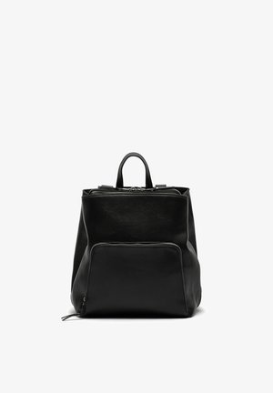 Sac à dos en cuir noir avec une poche zippée à l'avant, des poignées supérieures et une forme légèrement structurée sur fond blanc.