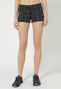 Mustat urheilushortsit, joissa on teksturoitu abstrakti kuvio. Ne on valmistettu joustavasta materiaalista ja niissä on tiukka malli sekä keski-ylöspäin oleva vyötärönauha.