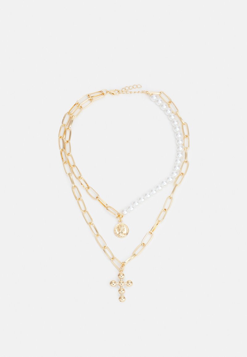 Guldtonet lagdelt halskæde med kædelinks og perler, med en cirkulær vedhæng og et guld kors i midten. Glat overflade, elegant design.