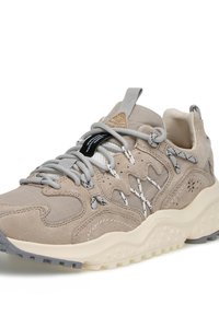 Beżowe trampki z zamszowym i teksturowanym materiałem. Posiadają szare sznurówki, białe akcenty oraz masywną podeszwę z wzorzystym bieżnikiem.