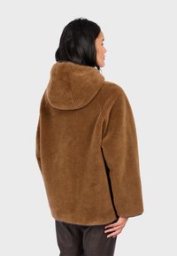 Braune übergroße Fleece-Jacke mit Kapuze, die eine weiche Textur und einen lockeren Sitz aufweist, von hinten gezeigt, mit klaren Linien und minimaler Ausstattung.