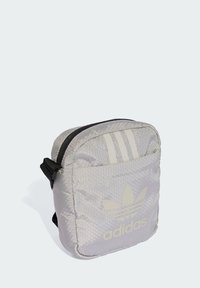 Borsa in tessuto grigia con motivo esagonale, zip nera, tracolla regolabile e logo Adidas bianco con tre strisce sul davanti.