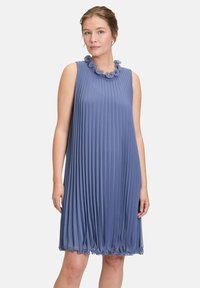 Robe sans manches plissée bleue avec un col texturé orné d'accents floraux. Silhouette fluide avec un ourlet arrondi. Finition en tissu lisse.