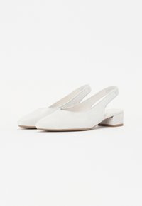 Chaussures blanches à bride arrière en matériau lisse avec un léger éclat, présentant un petit talon carré et un design à coupe angulée à l'avant.