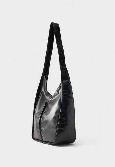 Μαύρη γυαλιστερή τσάντα ώμου με μακριά ράβδο και διακριτικές λεπτομέρειες στη ραφή, παρουσιάζεται σε λευκό φόντο.