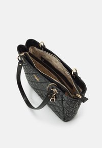 Sac à main matelassé noir avec ferrures dorées, présentant un extérieur texturé, des poignées doubles et plusieurs compartiments intérieurs.