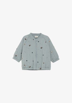 Helleblaue Zip-Jacke aus weichem Stoff, mit gepolsterten Ärmeln und verstreuten goldenen und braunen Punktmustern. Mit elastischen Bündchen und Saum.